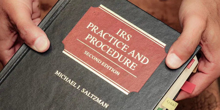 Hands holding the book IRS Practice and Procedure